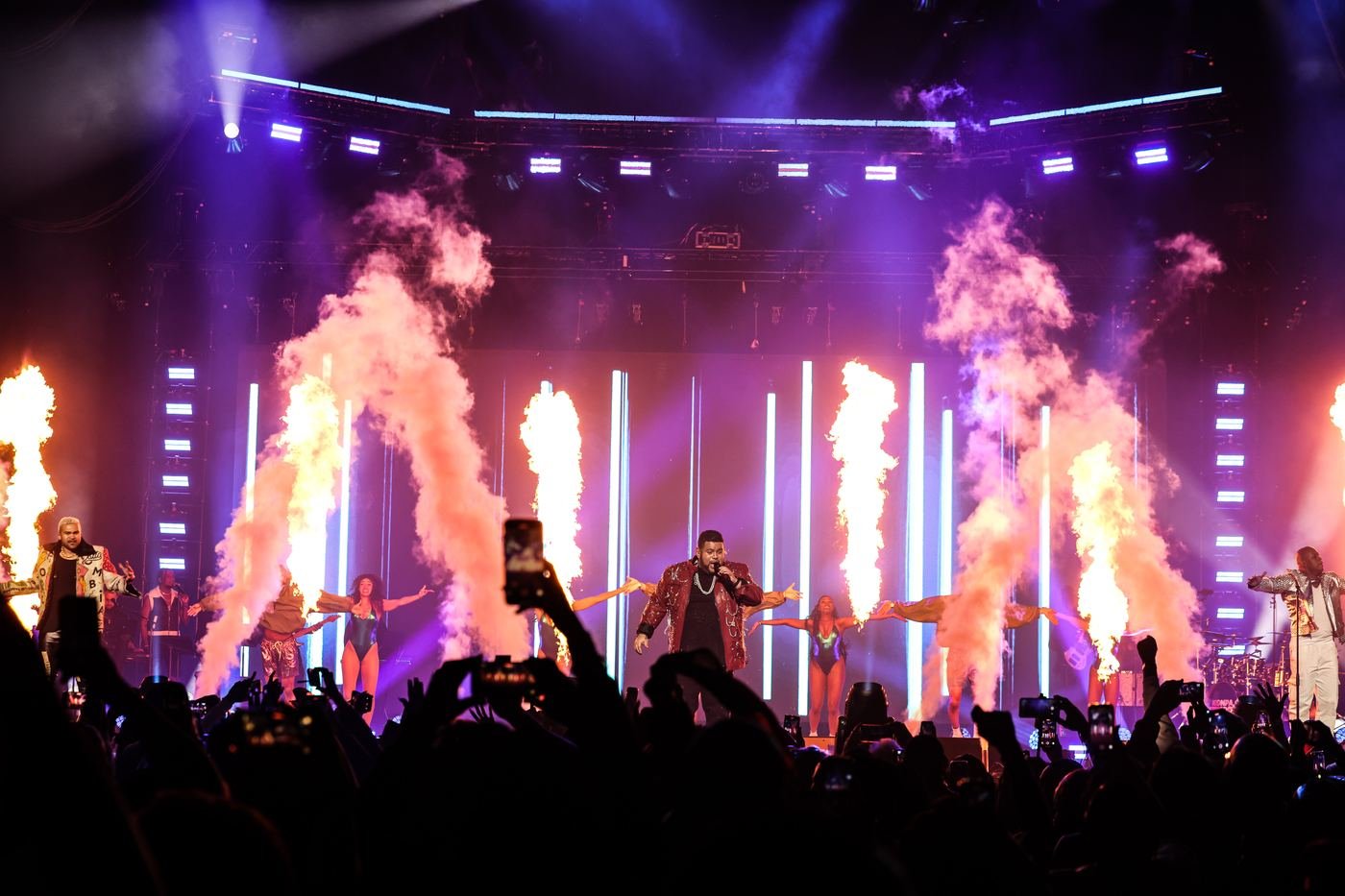 Mickael Guirand performing with flame effects and dancers on stage