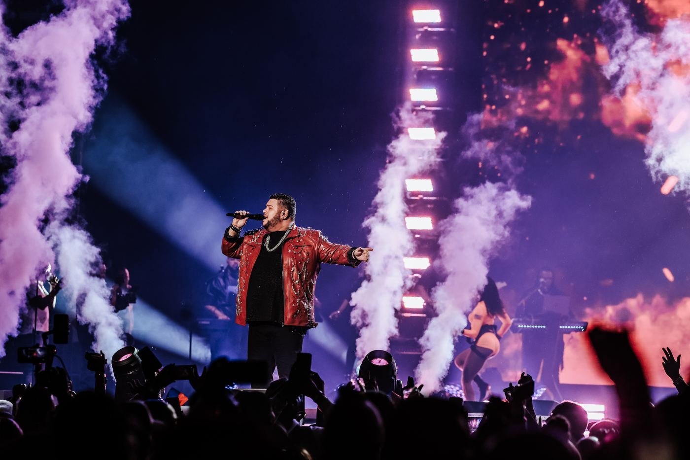Mickael Guirand singing on stage with smoke and pink lighting