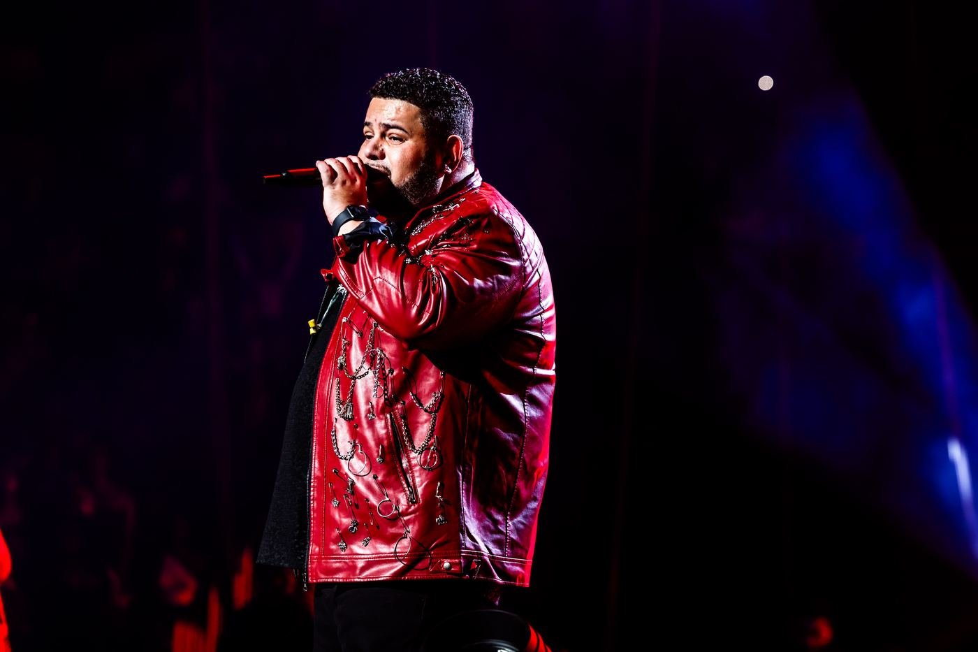 Close up of Mickael Guirand singing in a red jeweled jacket