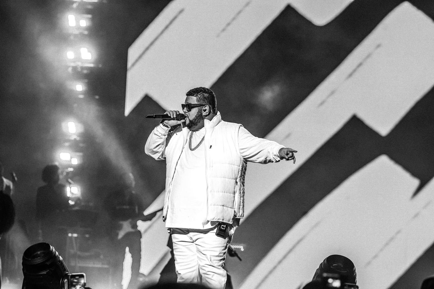 Black and white close up of Mickael Guirand singing in a white vest